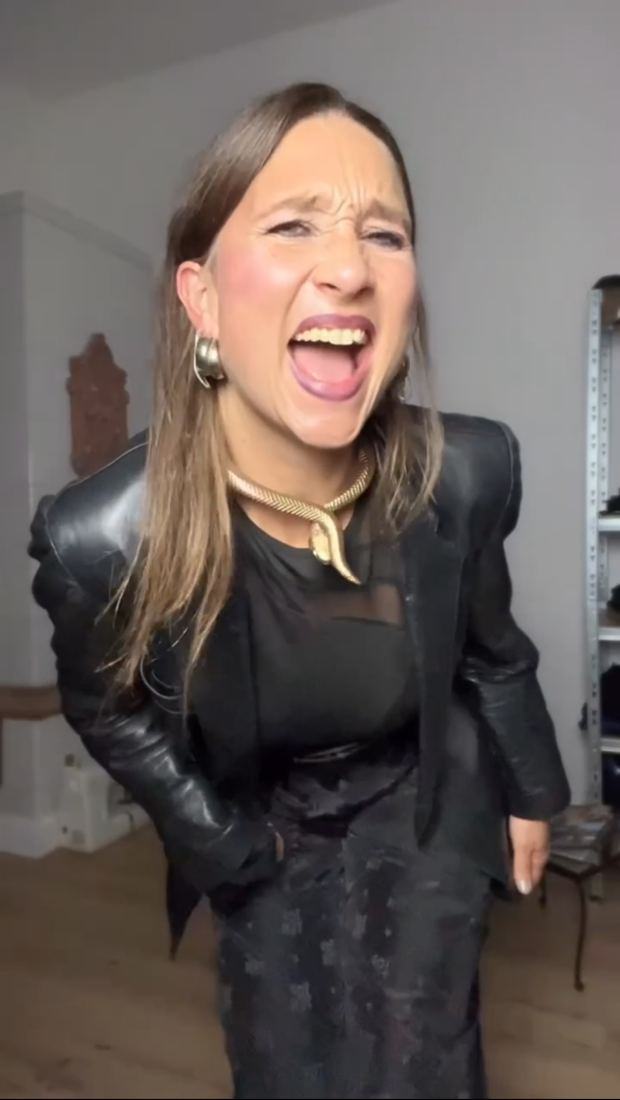 Alina lacht laut, in Lederjacke mit goldener Schlangenkette