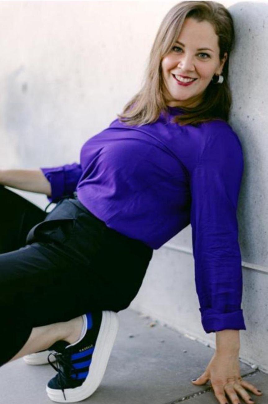 Jana auf ihrem neuen Shooting in violetter Bluse, schwarzer Hose und Sneakern