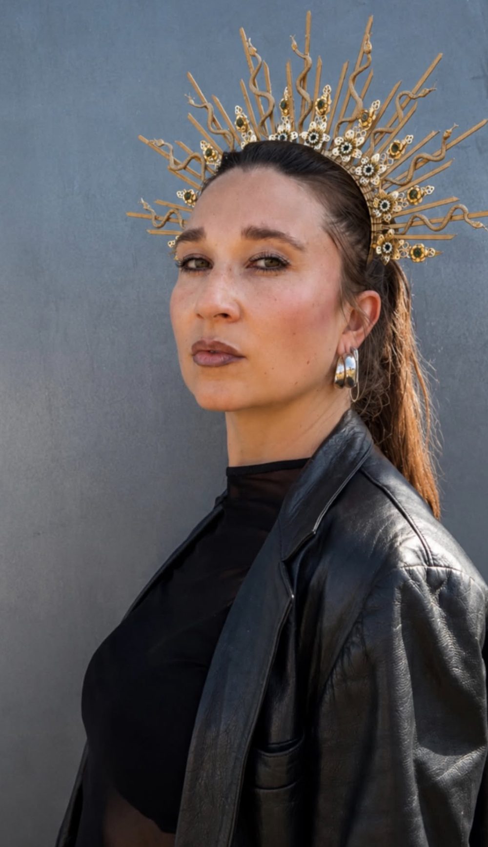 Alina mit goldener Strahlenkrone, Lederjacke und silbernen Ohrringen