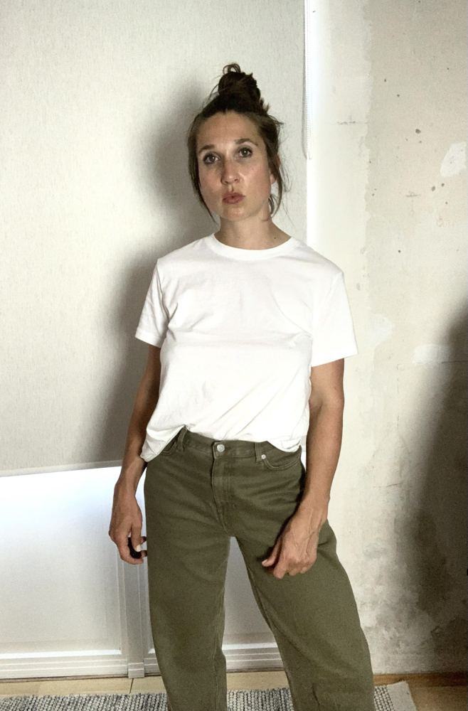 Alina in weißem T-Shirt und khakifarbener Jeans